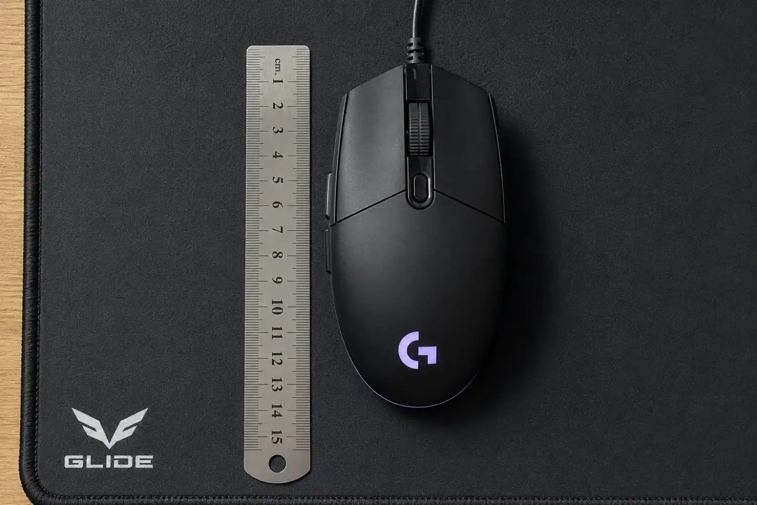 Gaming mouse placed next to a ruler on a mousepad to manually measure DPI.